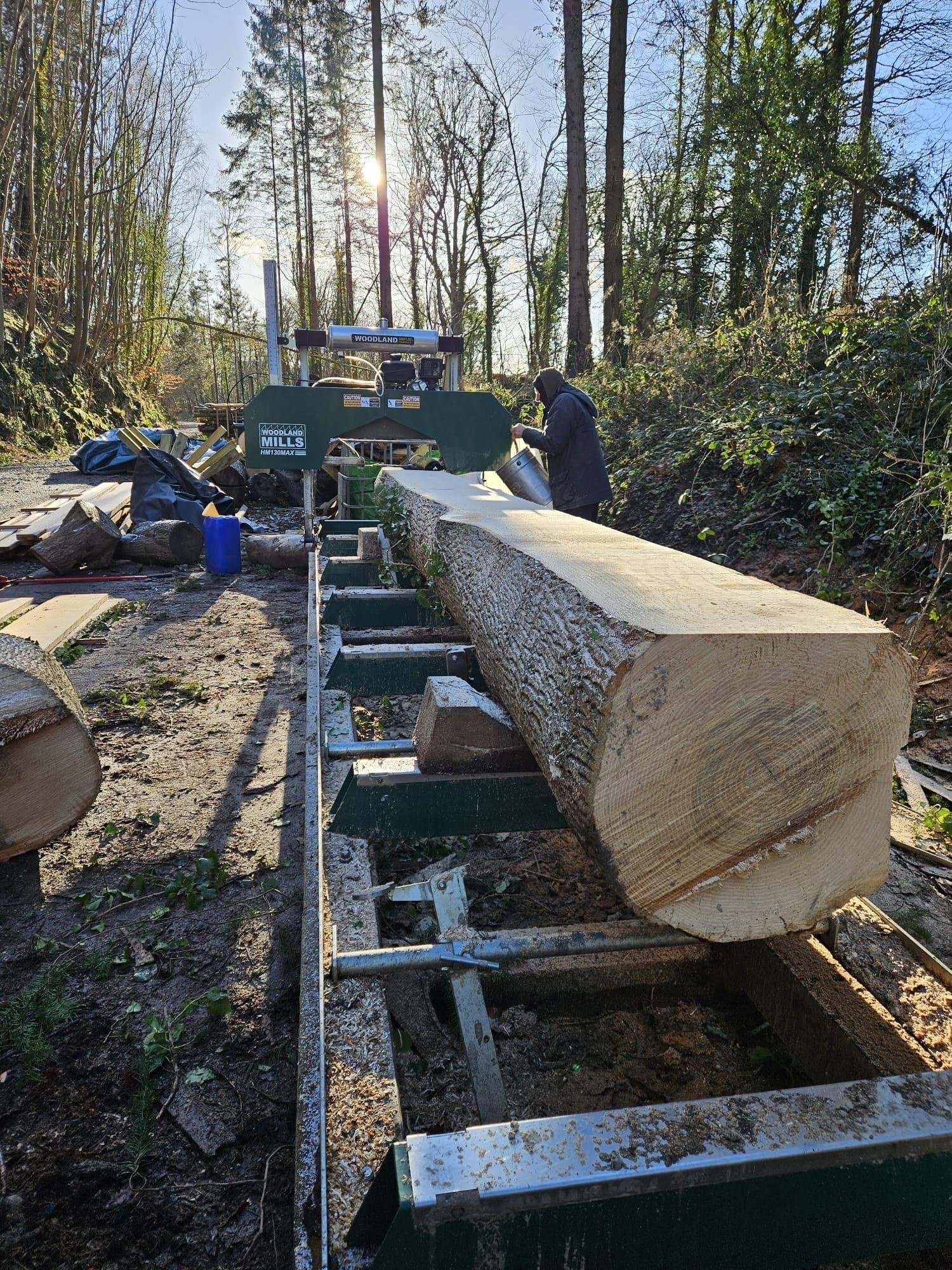 Large locally grown timber log being milled on site for sustainable woodland building projects in North Wales
