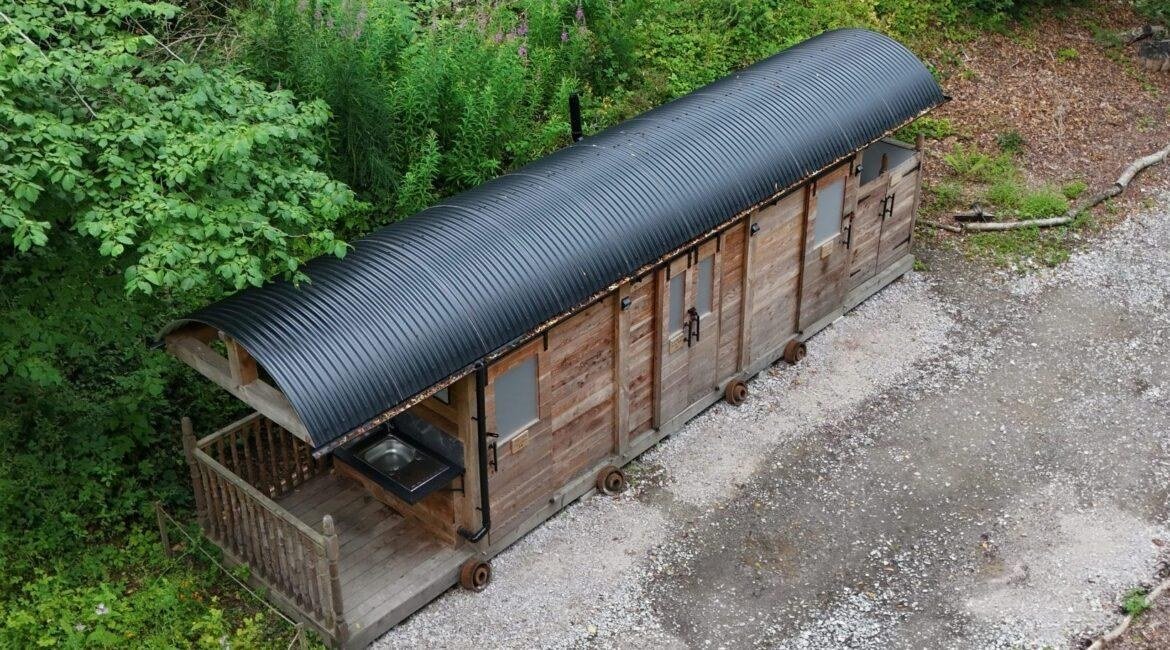Converted railway carriage toilet and shower facilities at a woodland campsite in North Wales
