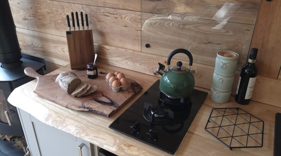 Handcrafted timber kitchen inside Toad Hideout woodland glamping cabin with wood burner and cooking facilities in North Wales