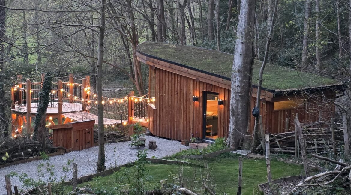 Toad Hideout woodland glamping cabin with living roof, rope bridge and private raised deck at Tree Tops and Train Tracks, North Wales