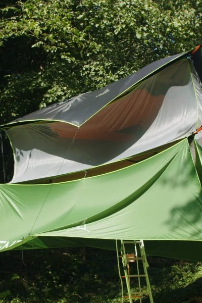 The Buzzard triple-level tree tent suspended among the trees at Tree Tops and Train Tracks woodland campsite in North Wales